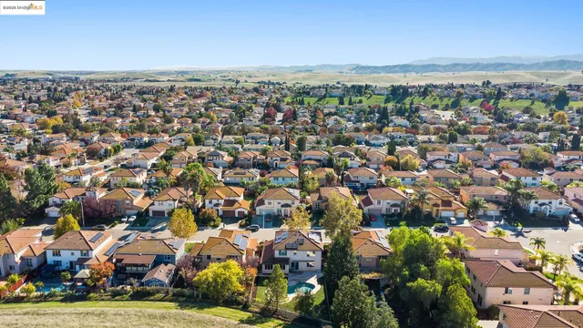 a view of a white house with a big yard and large trees