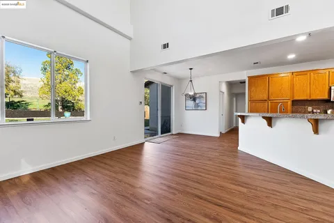a view of a big room with wooden floor and windows