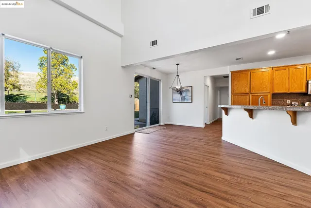 a view of a big room with wooden floor and windows