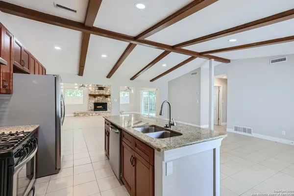 a kitchen with granite countertop a sink and a stove top oven
