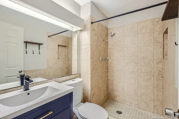 a bathroom with a sink toilet a mirror and shower