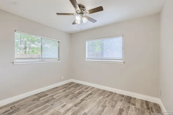a view of empty room with wooden floor