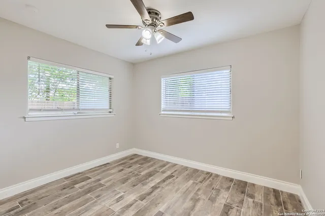 a view of empty room with wooden floor