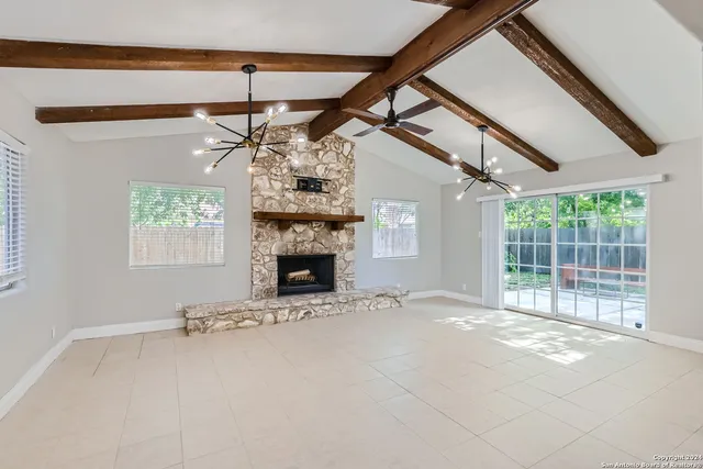 a view of empty room with a fireplace and fan