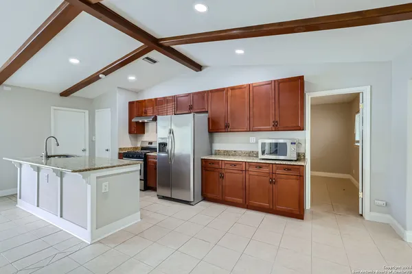 a kitchen with stainless steel appliances granite countertop a refrigerator sink and cabinets