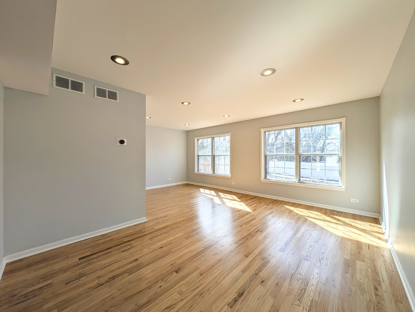 1030 Oak Ridge Drive Streamwood, IL 60107 - Photo 4 of 19 a view of an empty room with wooden floor and a window