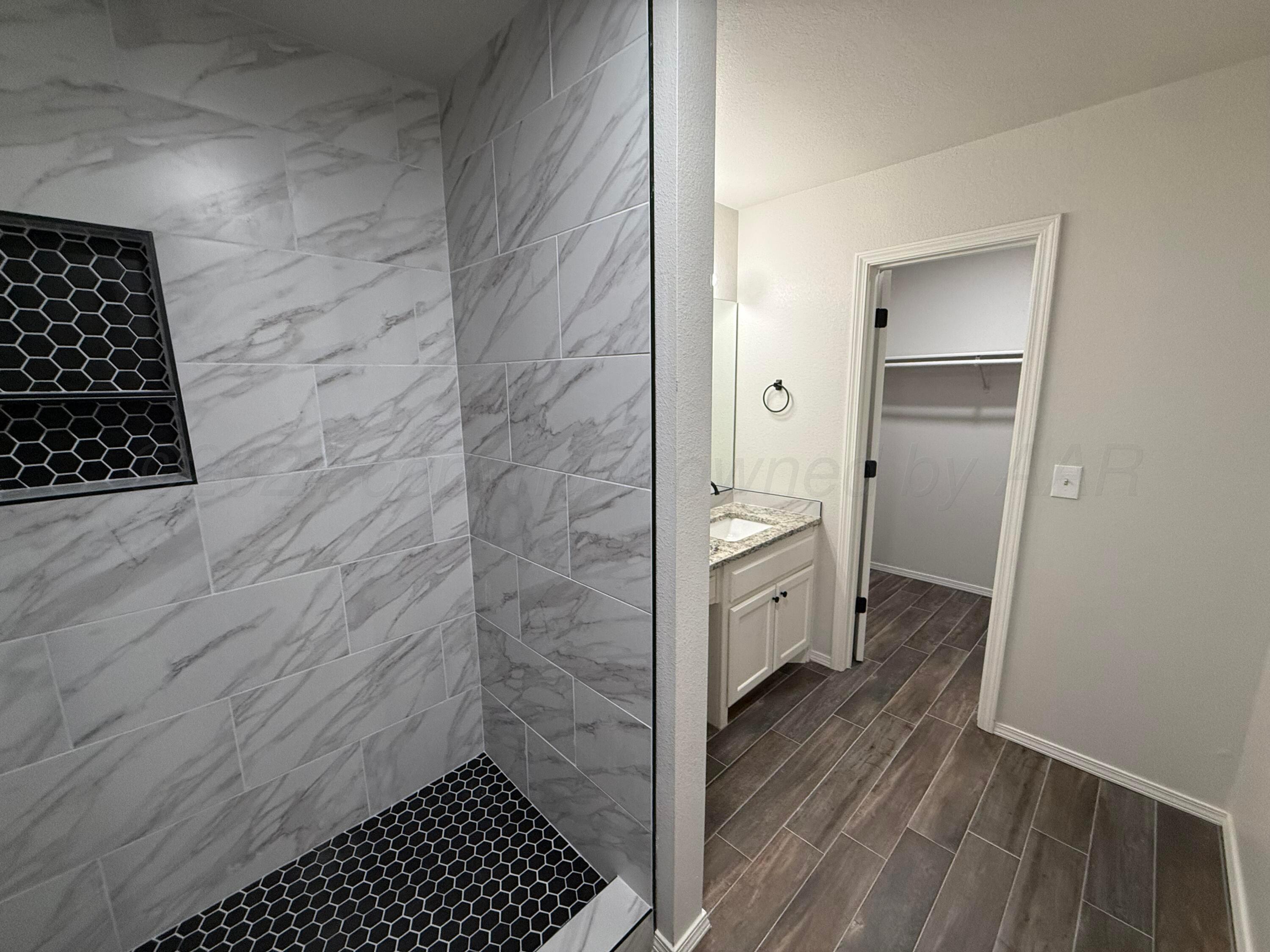 4914 Capulin Lane Amarillo, TX 79110 - Photo 14 of 25 a bathroom with a sink and a shower