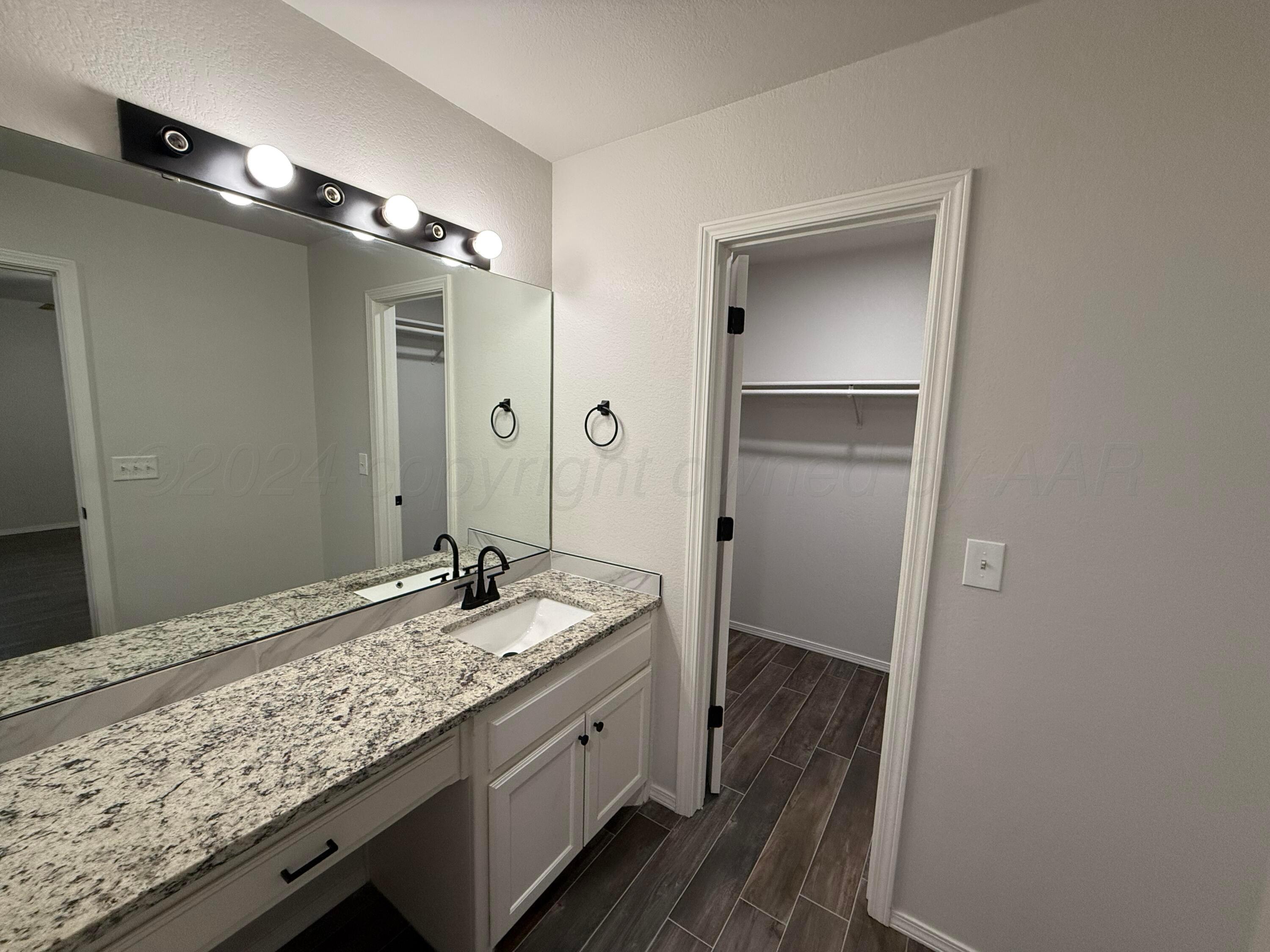 4914 Capulin Lane Amarillo, TX 79110 - Photo 16 of 25 a bathroom with a granite countertop sink and a mirror