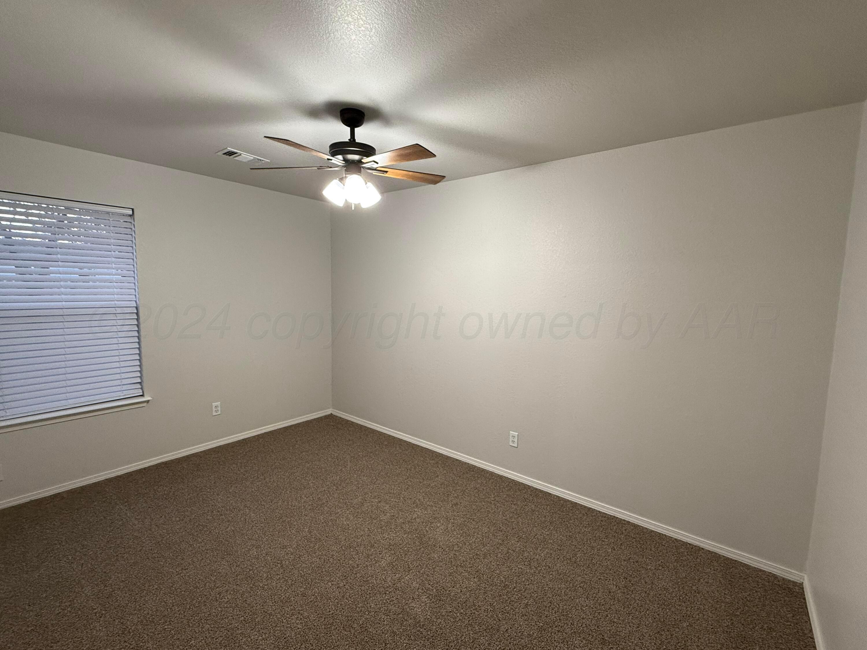 4914 Capulin Lane Amarillo, TX 79110 - Photo 18 of 25 an empty room with a window and a fan
