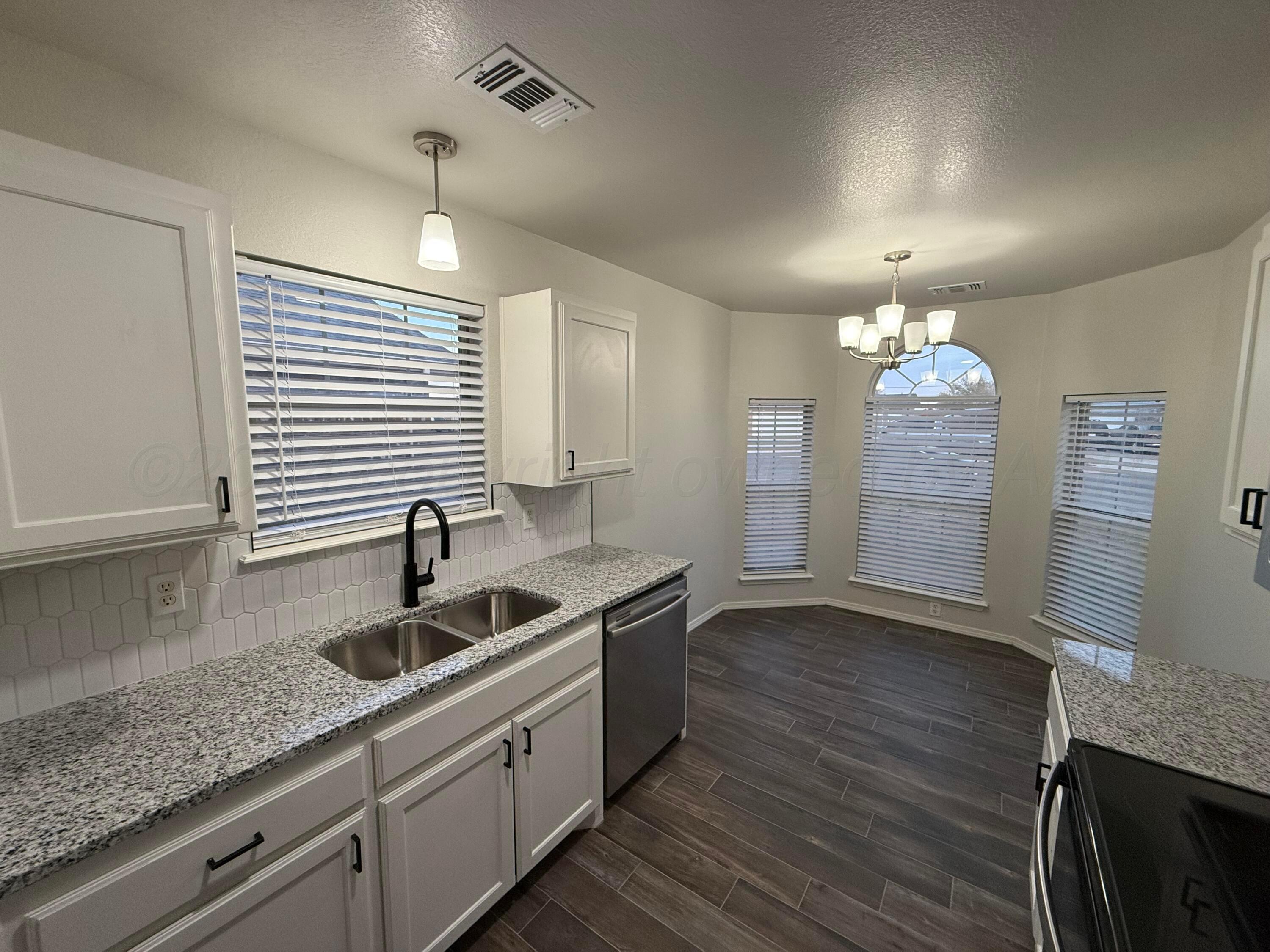 4914 Capulin Lane Amarillo, TX 79110 - Photo 6 of 25 a kitchen with granite countertop a sink a counter space and cabinets
