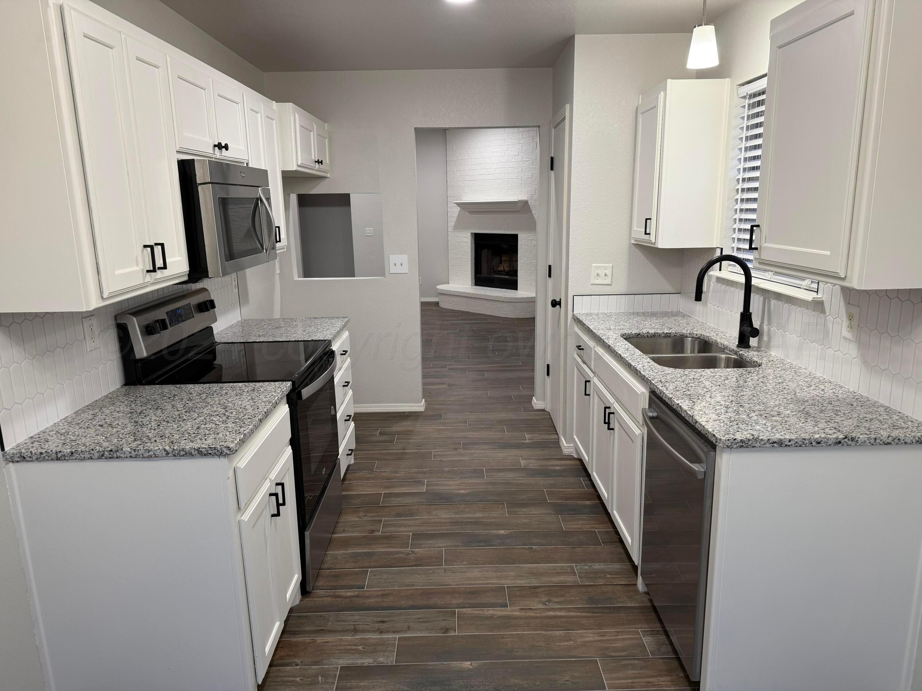4914 Capulin Lane Amarillo, TX 79110 - Photo 7 of 25 a kitchen with stainless steel appliances granite countertop a sink stove and refrigerator