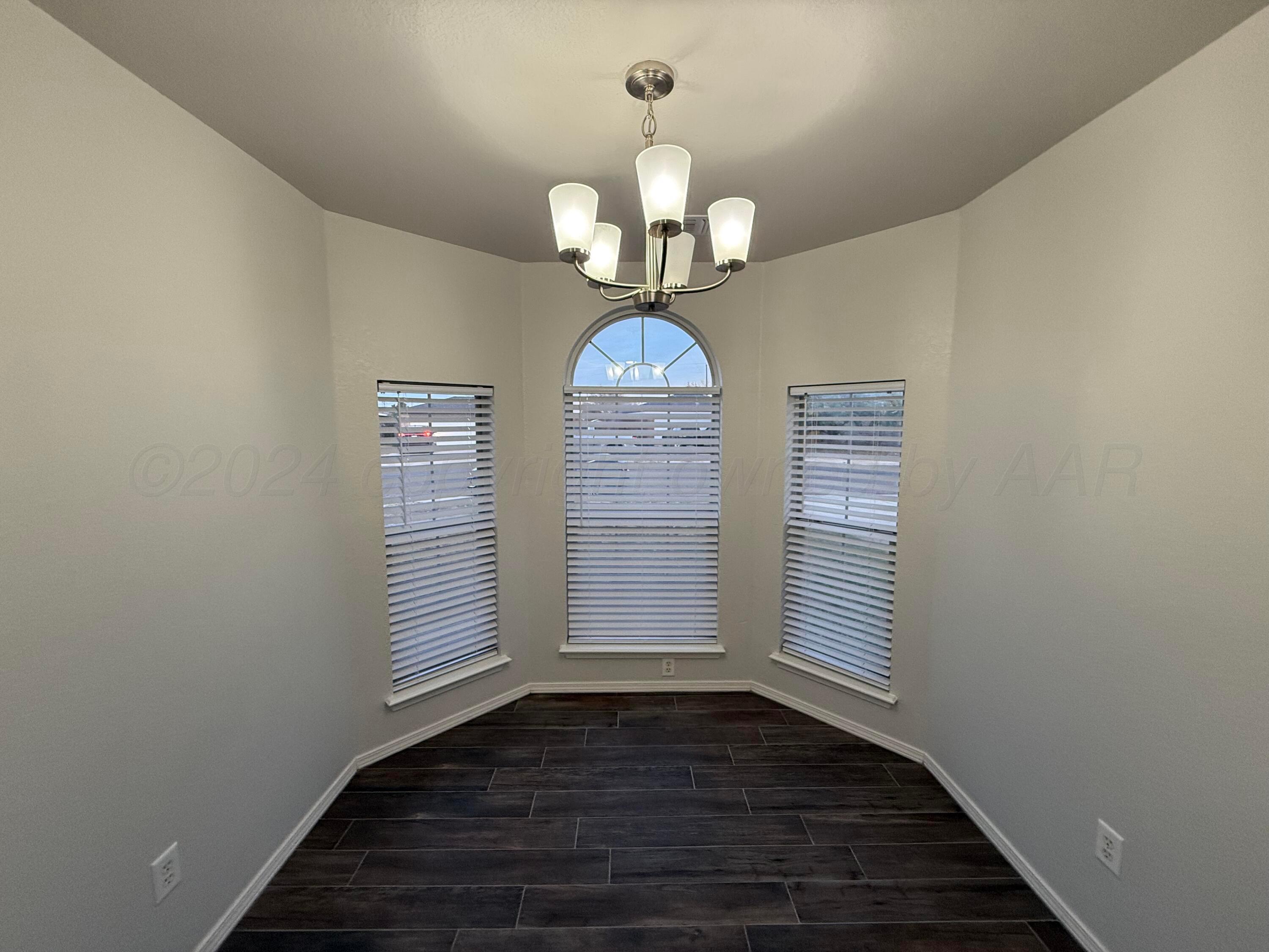4914 Capulin Lane Amarillo, TX 79110 - Photo 8 of 25 a view of wooden floor windows and chandelier in a room