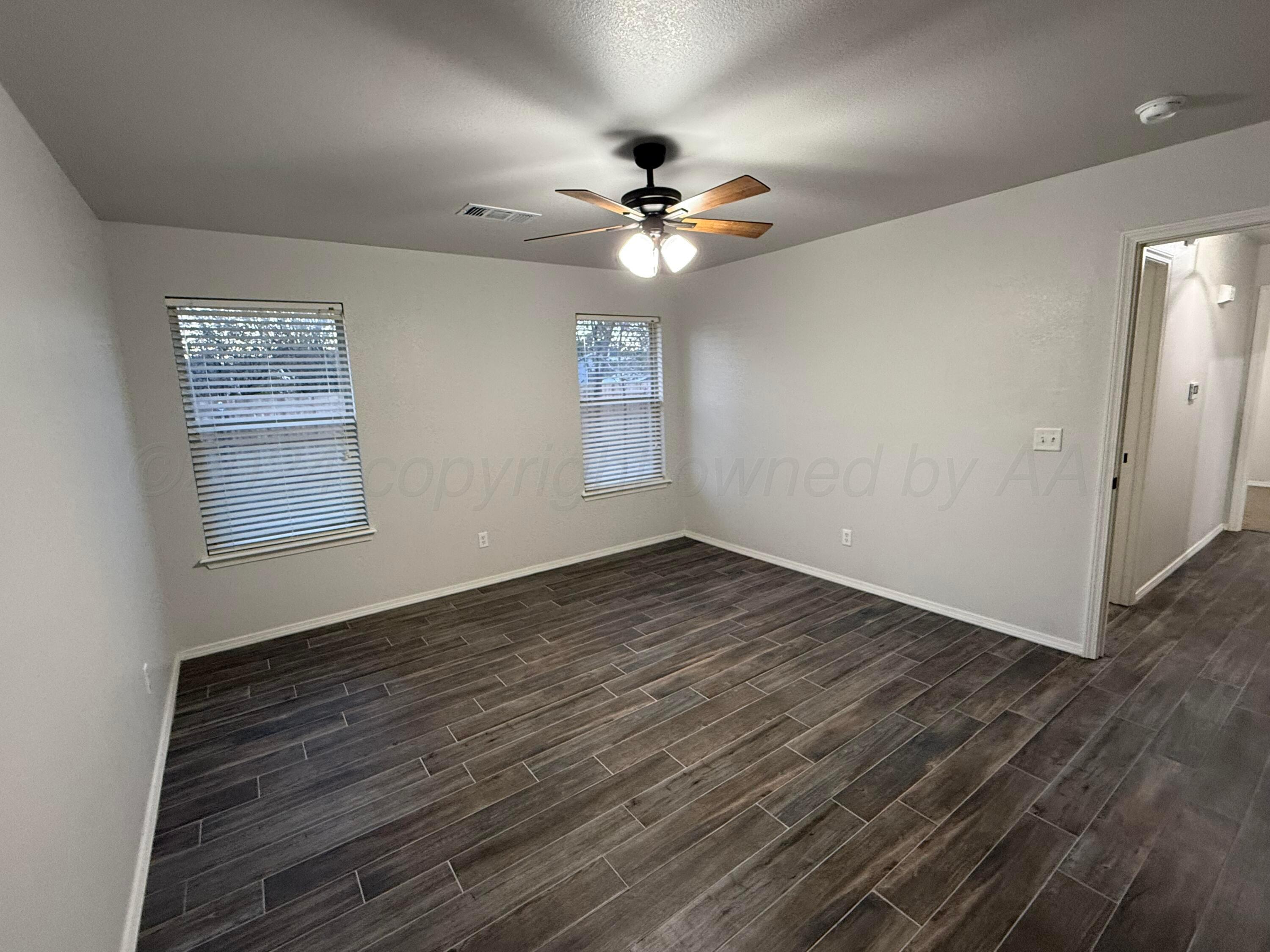 4914 Capulin Lane Amarillo, TX 79110 - Photo 9 of 25 wooden floor in an empty room with a window