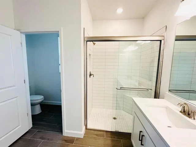 a bathroom with a sink a toilet and shower