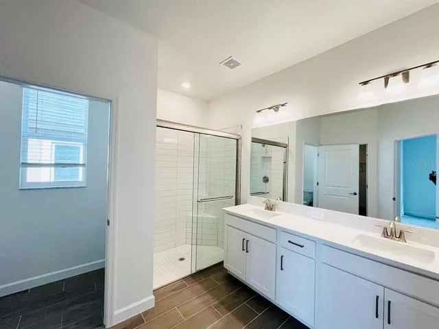 a spacious bathroom with a double vanity sink mirror and double