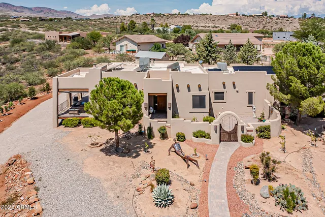 an aerial view of a house with a yard and wooden fence