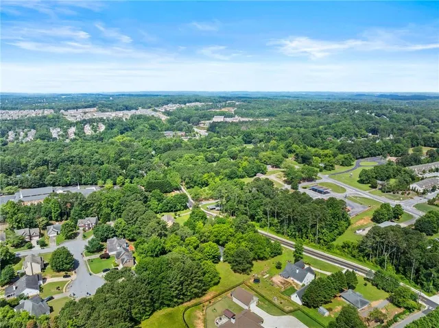 an aerial view of residential houses with outdoor space and trees