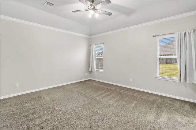 an empty room with a window and a fan