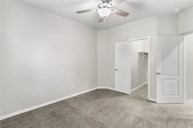 an empty room with chandelier fan