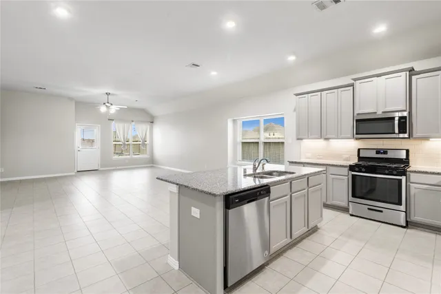 a kitchen with granite countertop kitchen island a sink appliances and cabinets