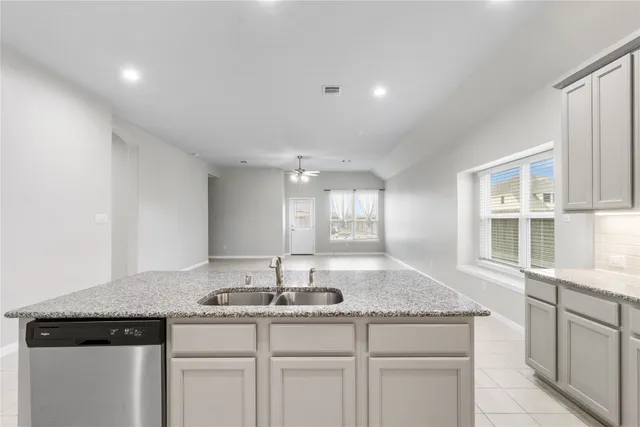 a kitchen with stainless steel appliances granite countertop a sink and a stove
