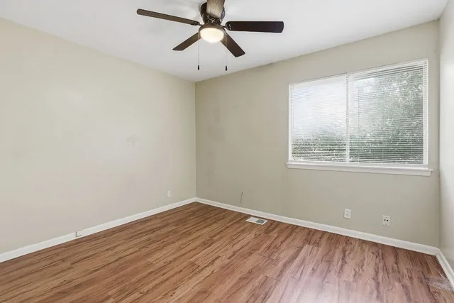 wooden floor in an empty room with a window