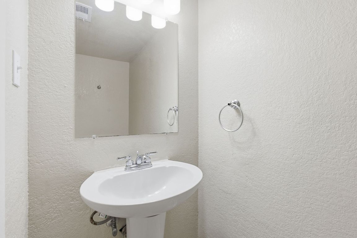 8809 Dawnridge Circle, Unit 102 Austin, TX 78757 - Photo 14 of 18 a bathroom with a sink a mirror and a shower