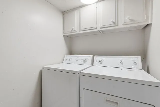 a utility room with dryer and cabinets