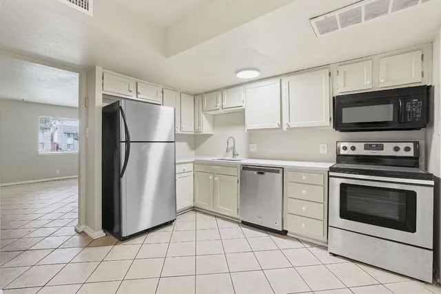 a kitchen with cabinets stainless steel appliances and a counter space