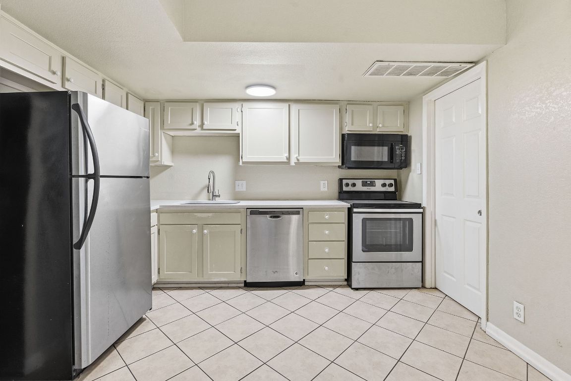 8809 Dawnridge Circle, Unit 102 Austin, TX 78757 - Photo 6 of 18 a kitchen with a refrigerator sink and stove