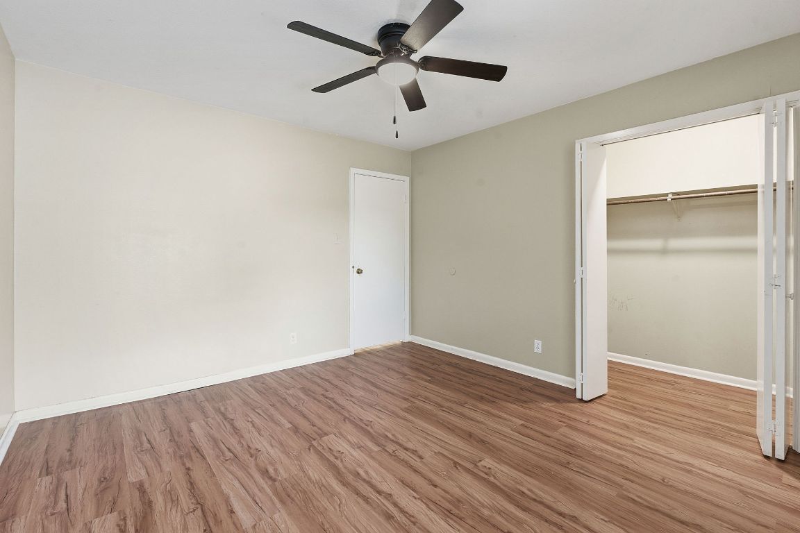 8809 Dawnridge Circle, Unit 102 Austin, TX 78757 - Photo 10 of 18 an empty room with wooden floor and windows