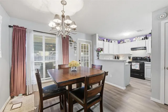 a view of a dining room with furniture and chandelier