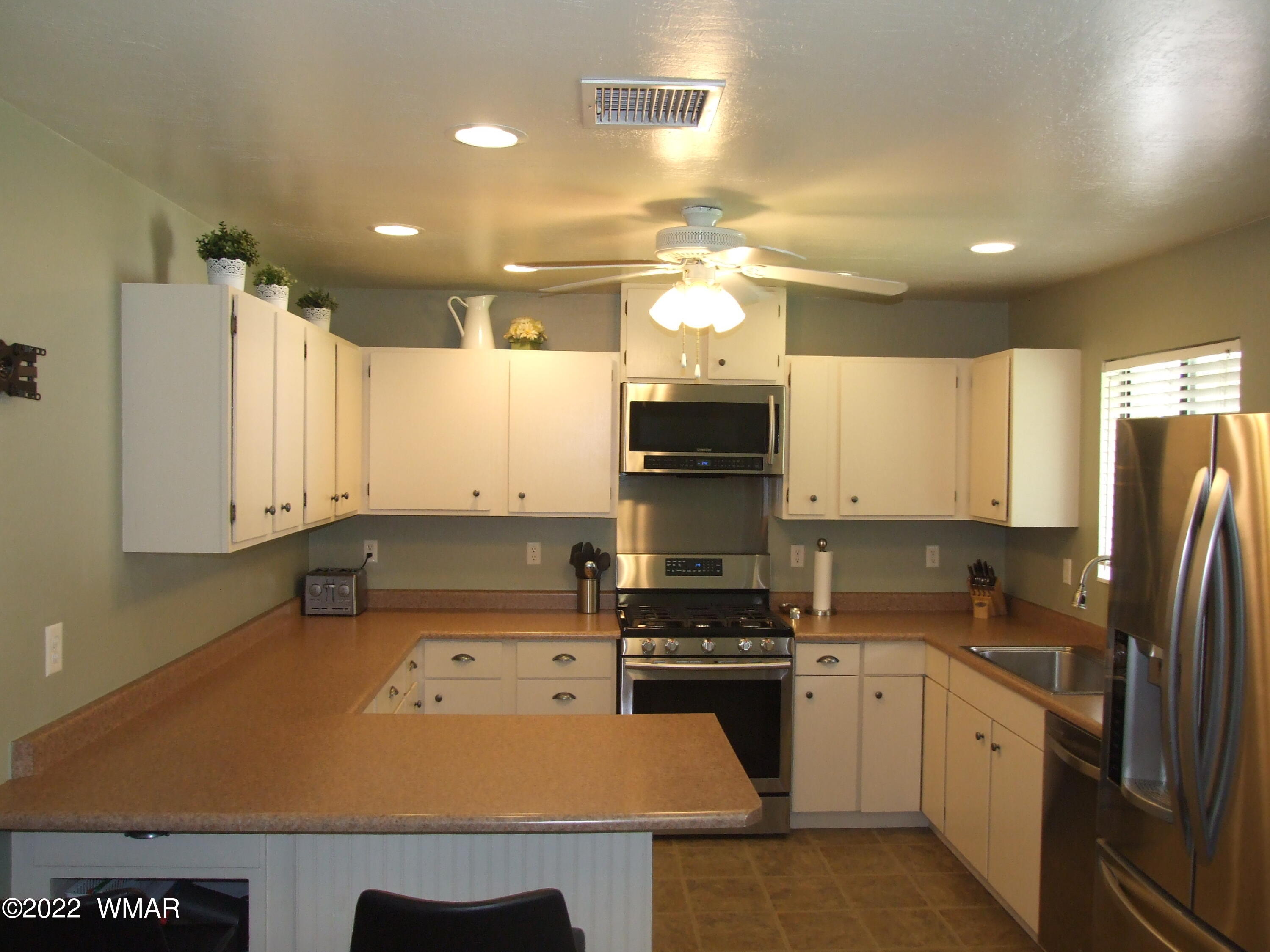 49 North 4th W Street Snowflake, AZ 85937 - Photo 23 of 34 a kitchen with a refrigerator a stove top oven a sink and cabinets