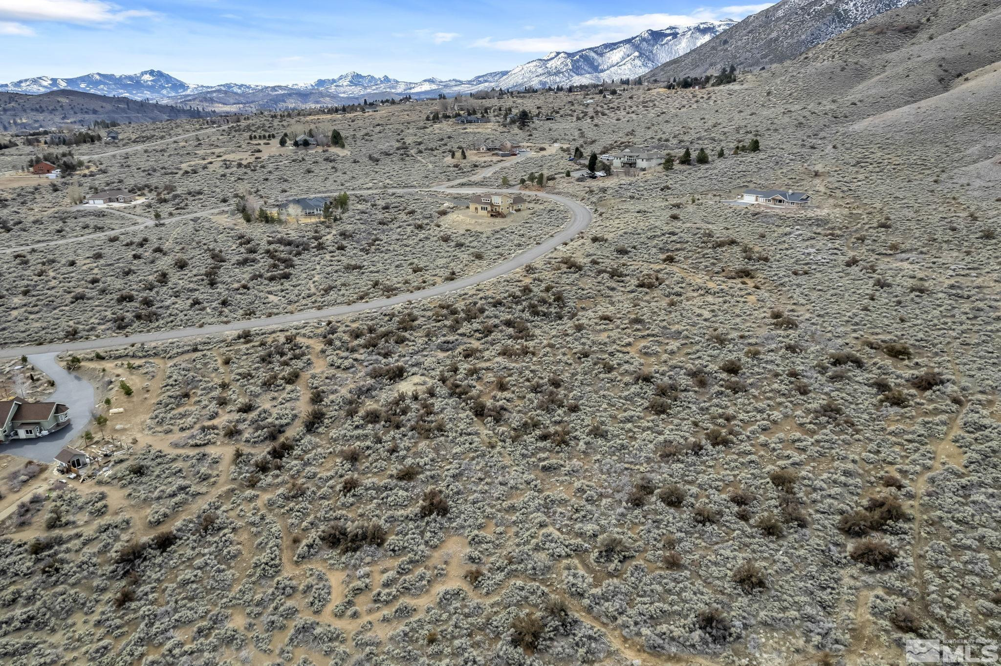 a view of a dry yard with mountains in the background