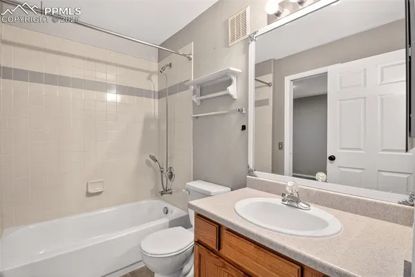 a bathroom with a sink toilet tub vanity and shower