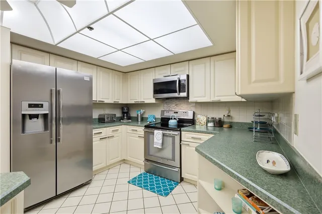 a kitchen with stainless steel appliances granite countertop a refrigerator a stove top oven a sink and dishwasher