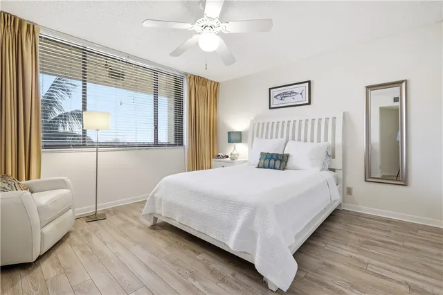 a bedroom with a bed and a large window