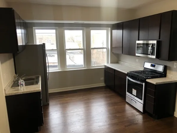 a kitchen with stainless steel appliances granite countertop a stove a sink and a microwave