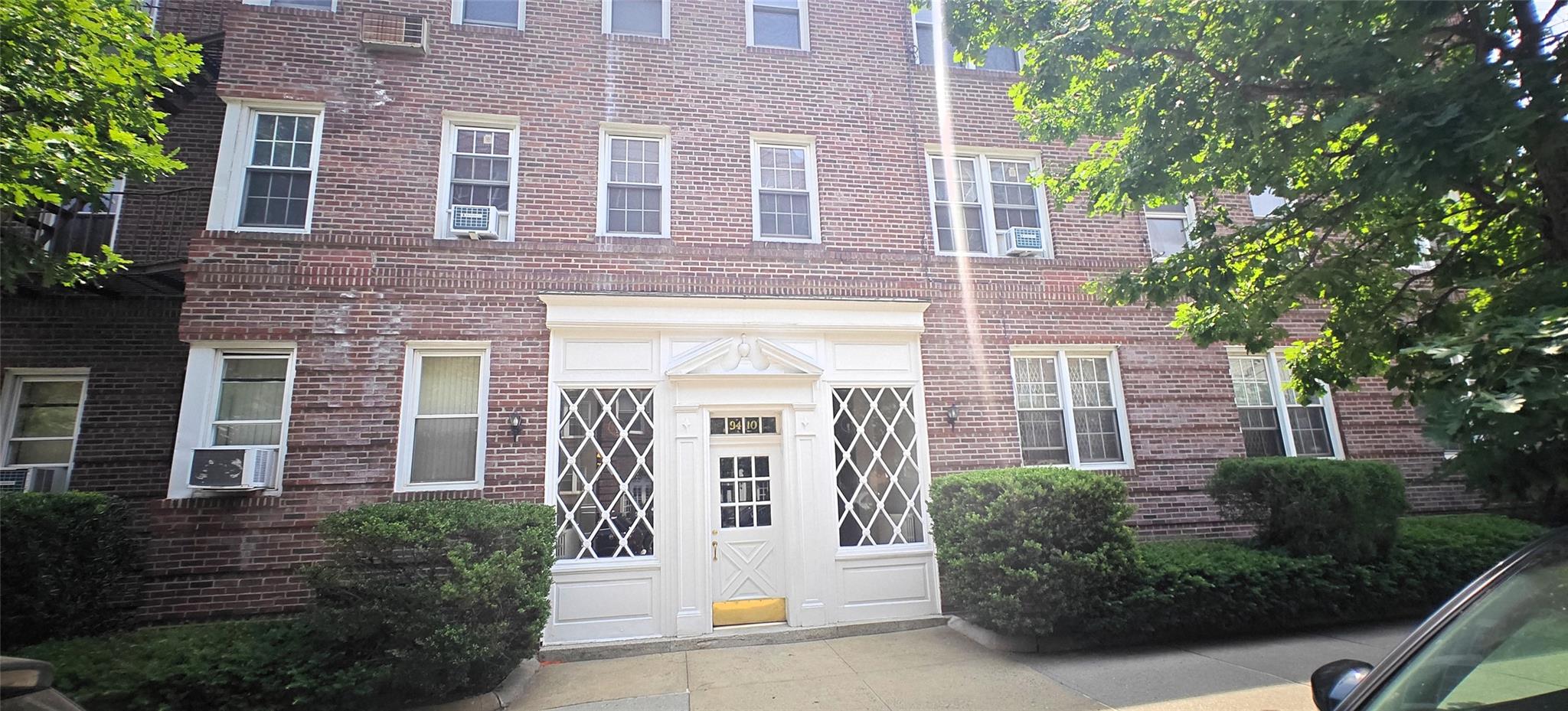94-10 64th Road, Unit B6 Queens, NY 11374 - Photo 15 of 17 View of exterior entry with brick siding and cooling unit