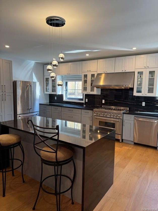 a kitchen with stainless steel appliances wooden cabinets a stove a sink and a refrigerator