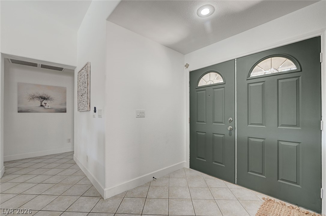 1072 Reed Point Court Henderson, NV 89002 - Photo 8 of 60 Enter this home through a double door entry, welcoming you with tile flooring and a brightly illuminated hallway.