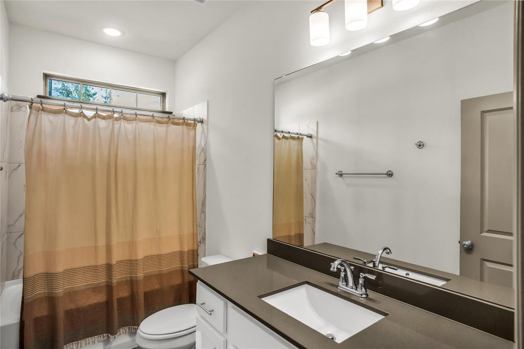 999 Emil Place Allen, TX 75013 - Photo 19 of 29 a bathroom with a sink a toilet a mirror and shower