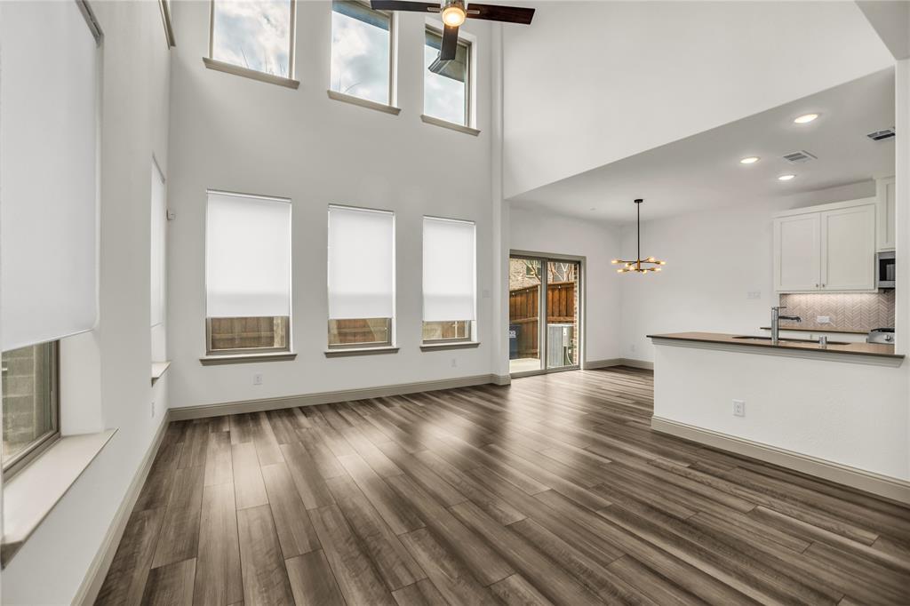 999 Emil Place Allen, TX 75013 - Photo 3 of 29 a view of an empty room with wooden floor and a window