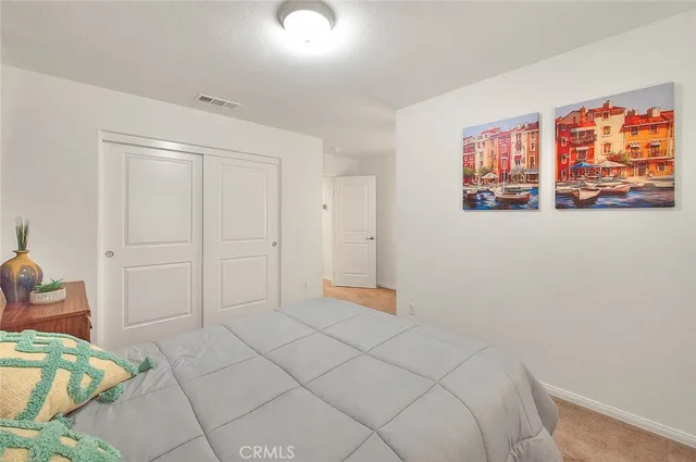a spacious bedroom with a bed and painting on the wall
