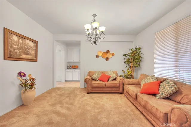 a living room with furniture chandelier and a window
