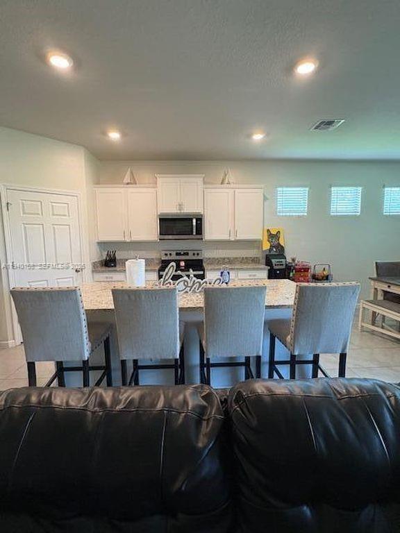 571 Old Country Rd S East Palm Bay, FL 32909 - Photo 28 of 29 a living room with stainless steel appliances furniture a dining table and kitchen view