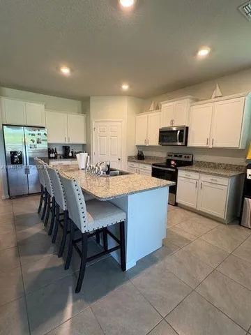 a kitchen with a sink a counter top space appliances and a center island