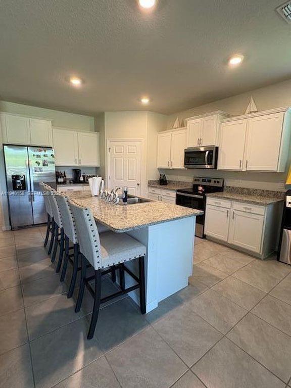 571 Old Country Rd S East Palm Bay, FL 32909 - Photo 6 of 29 a kitchen with a sink a counter top space appliances and a center island