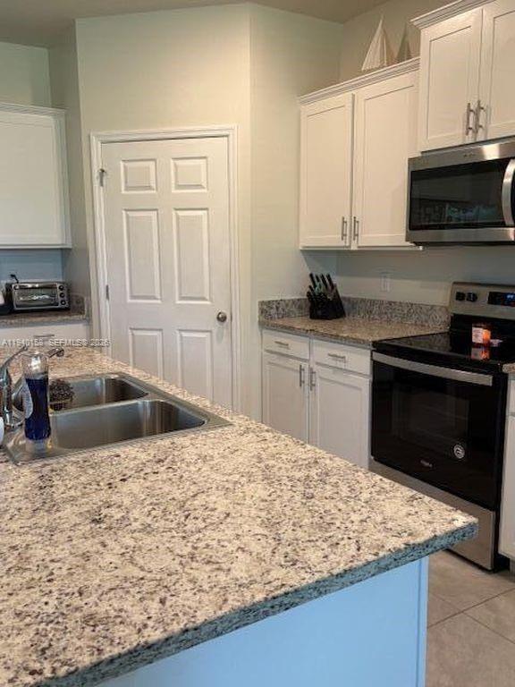 571 Old Country Rd S East Palm Bay, FL 32909 - Photo 7 of 29 a kitchen with stainless steel appliances granite countertop a sink stove and refrigerator