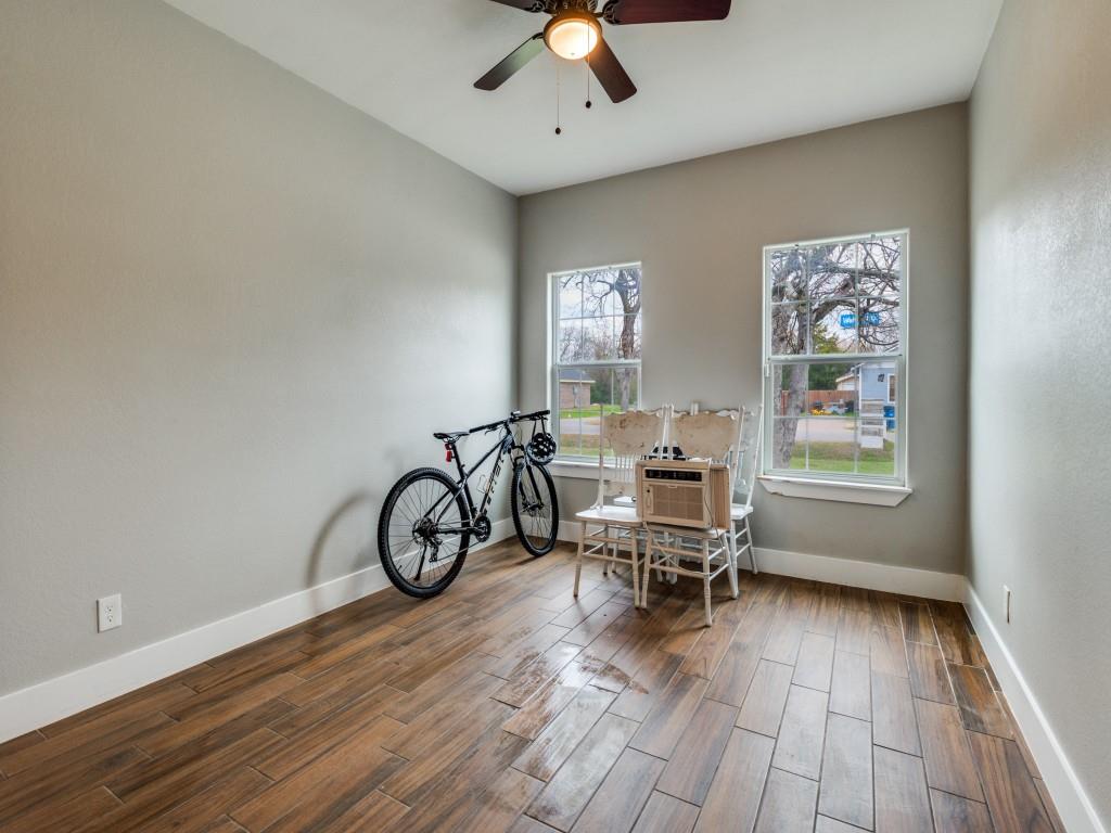 908 East Decatur Street Ennis, TX 75119 - Photo 20 of 22 a view of workspace with wooden floor ceiling fan and windows